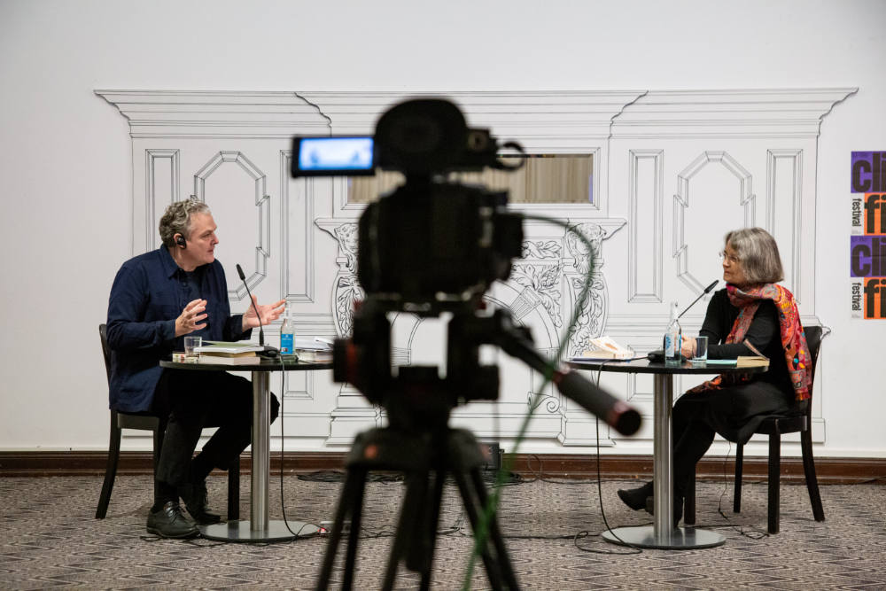 Martin Zähringer und Sieglinde Geisel im Gespräch. In der Bildmitte eine Kamera. die das Gespräch aufzeichnet.